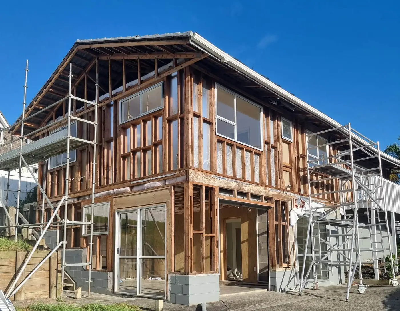 Two-storey house stripped to framing under scaffold