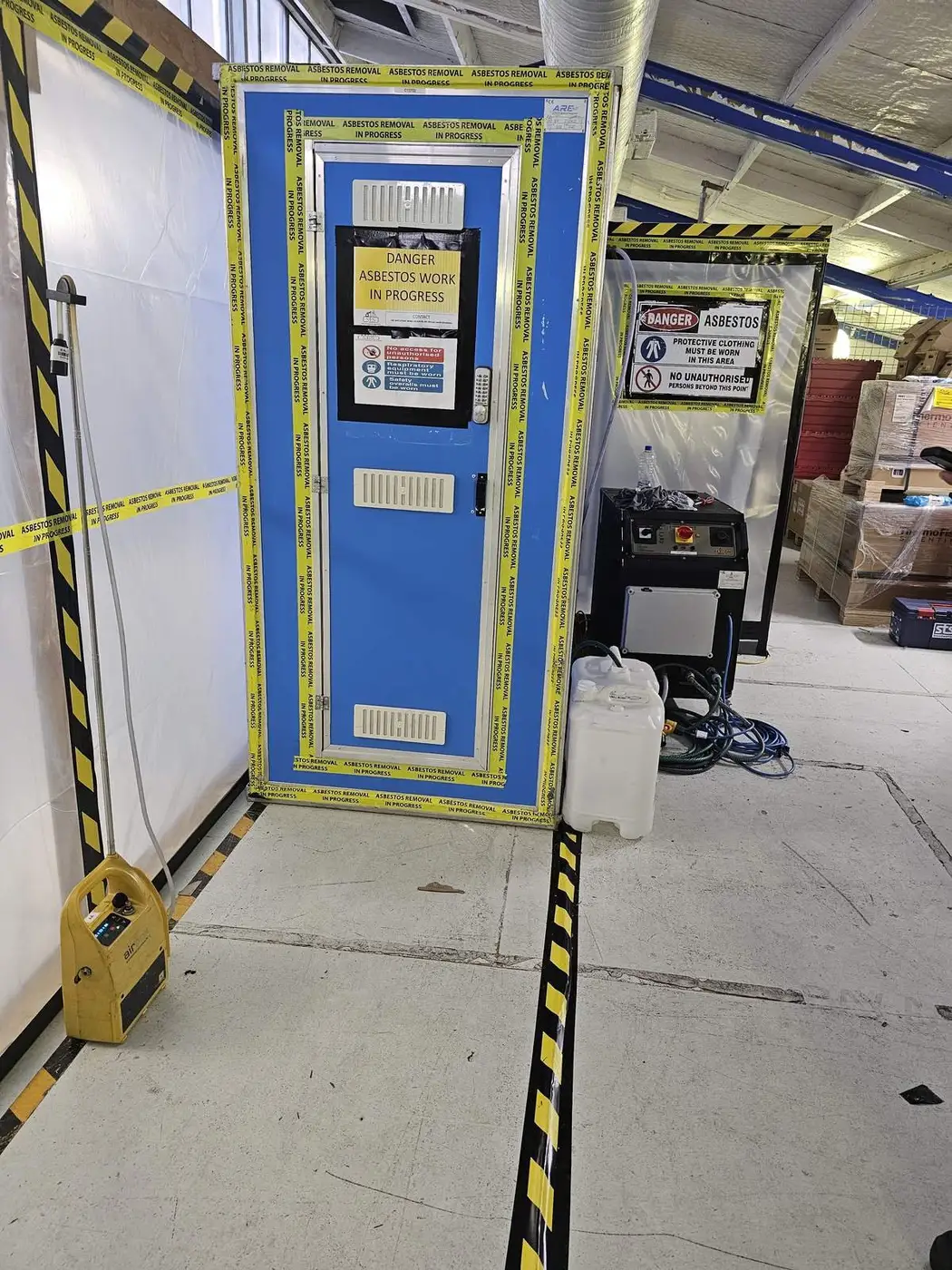 Asbestos enclosure and decontamination unit entry in a warehouse