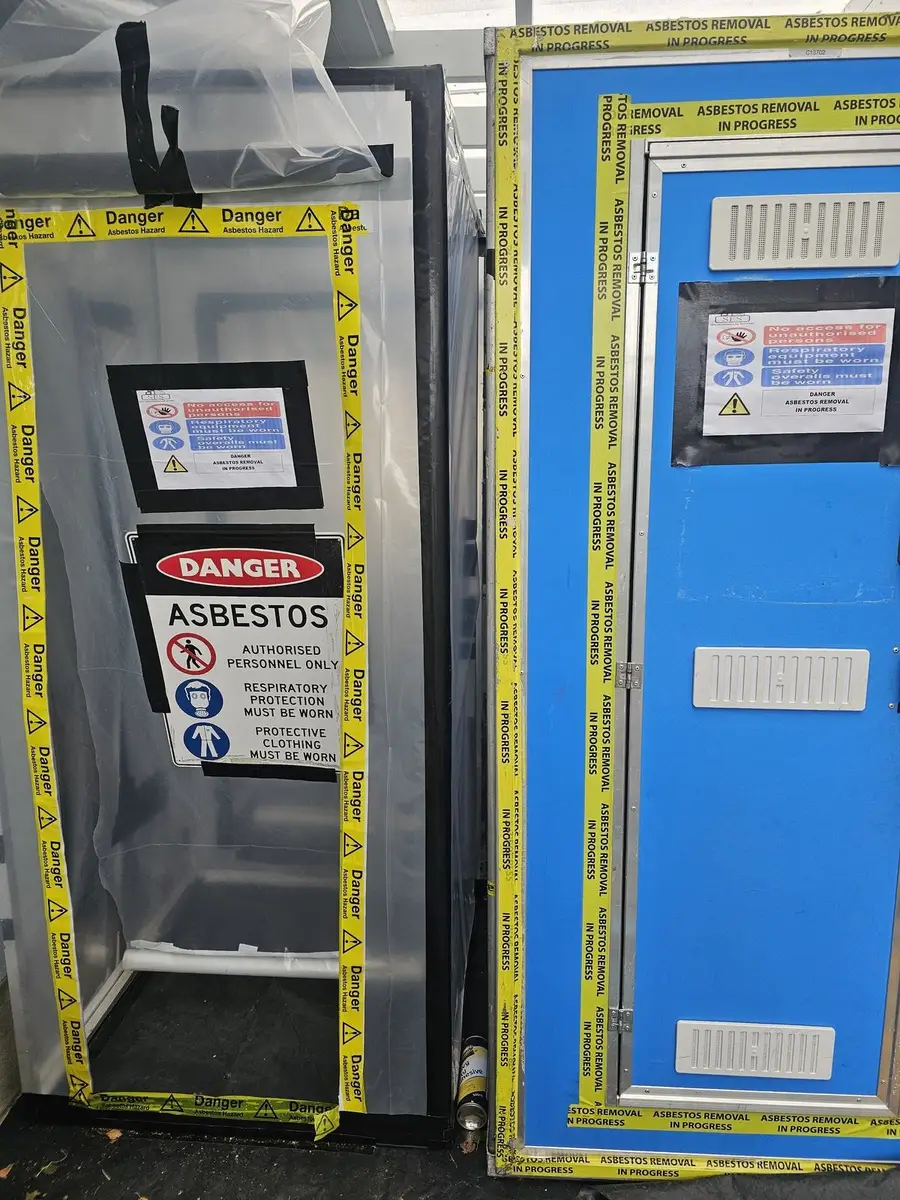Decontamination unit with danger asbestos sign in the warehouse